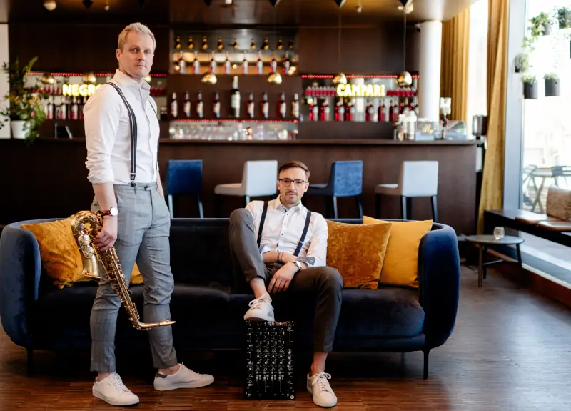 DJ und Saxophonist spielen Livemusik auf einem Firmenevent.